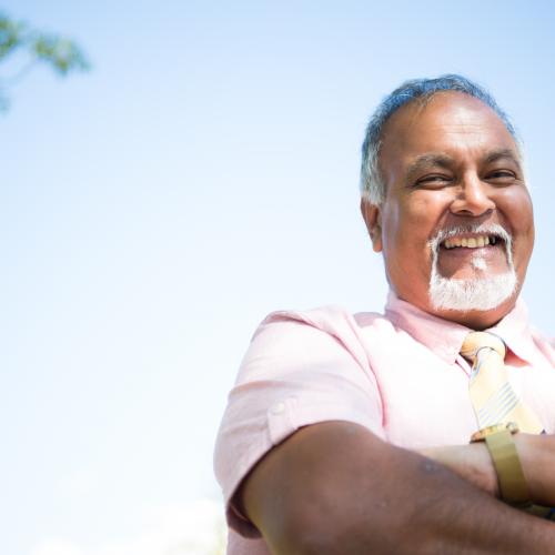 a man with a beard, arms folded smiling at the camera