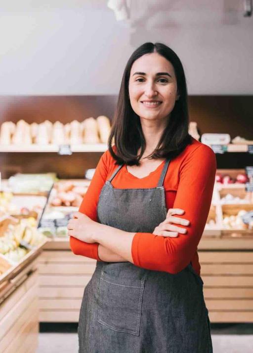 Une femme souriante au milieu de sa boutique artisanale
