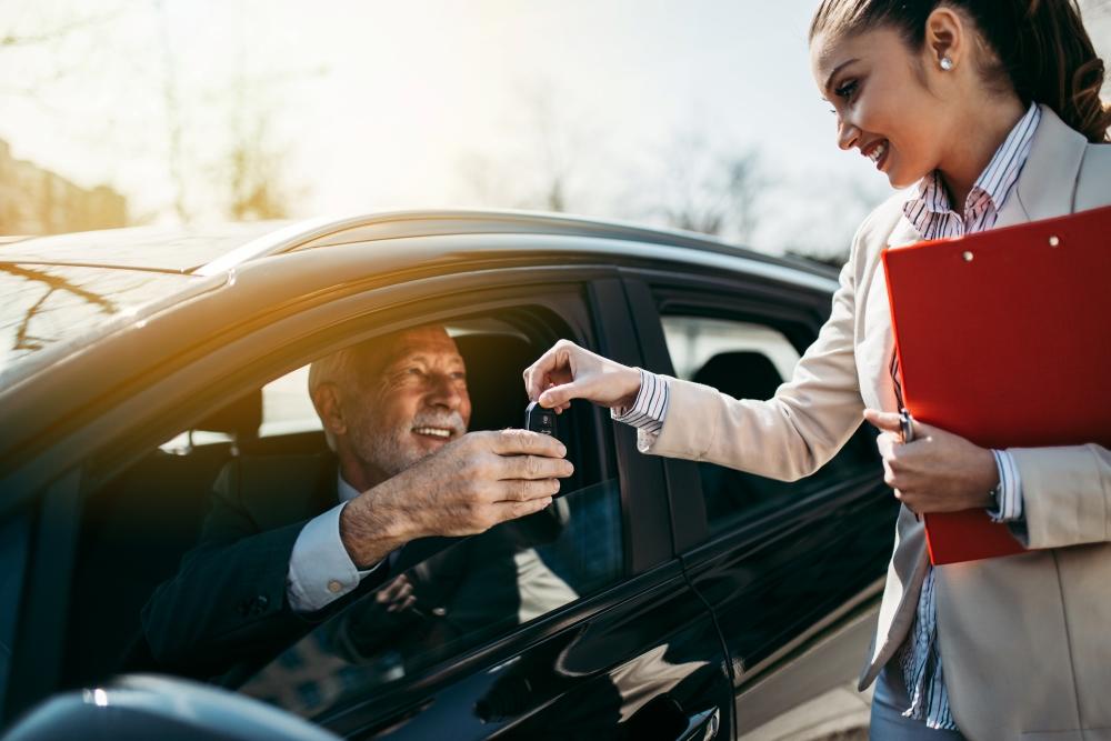 Handing key to male driver